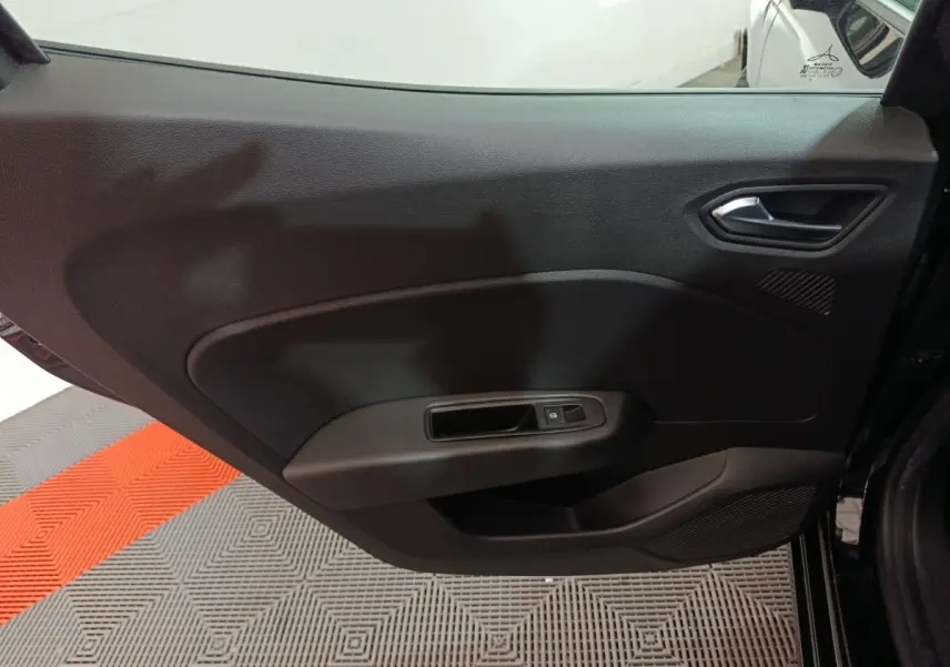 Vue intérieure côté gauche de la porte arrière noire de la Renault Clio 2025 avec poignée et commande de fenêtre électrique.