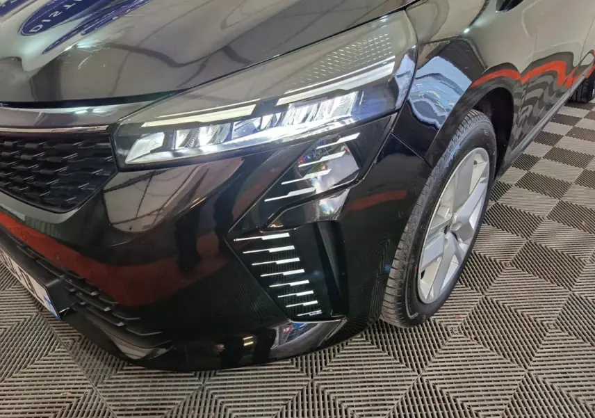 Vue rapprochée 3/4 avant droit d’une Renault Clio noire mettant en valeur ses phares LED et la jante alliage.