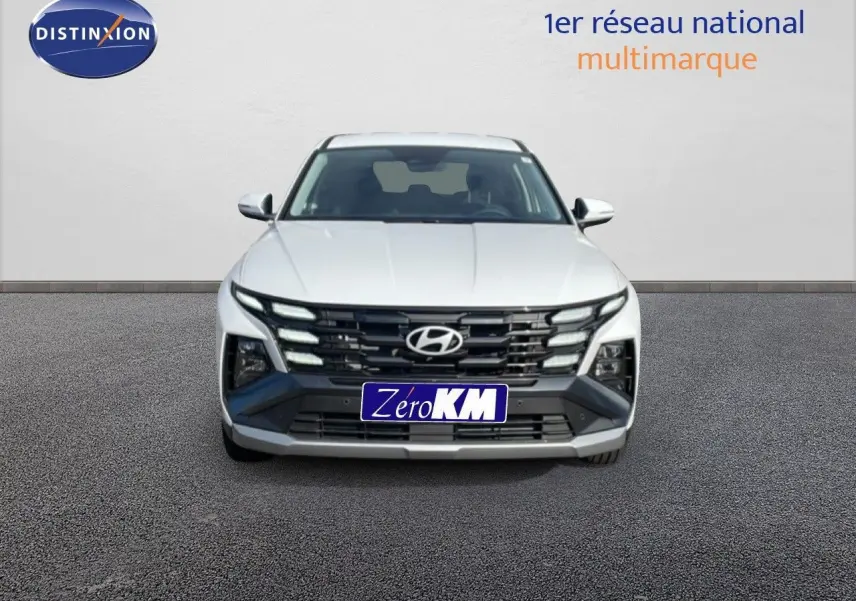 Hyundai Tucson blanc Atlas 2026 vu de face, mettant en valeur sa calandre distinctive et ses phares LED intégrés.