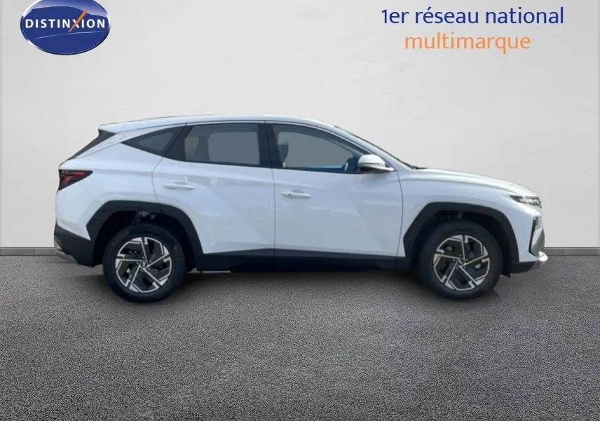 Vue de profil côté droit d'un Hyundai Tucson blanc Atlas 2026 avec jantes alliage et lignes anguleuses marquées.