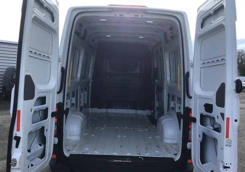Vue arrière du Volkswagen Crafter Fourgon blanc L3H3 2021 avec portes ouvertes montrant l'espace de chargement vide et spacieux.