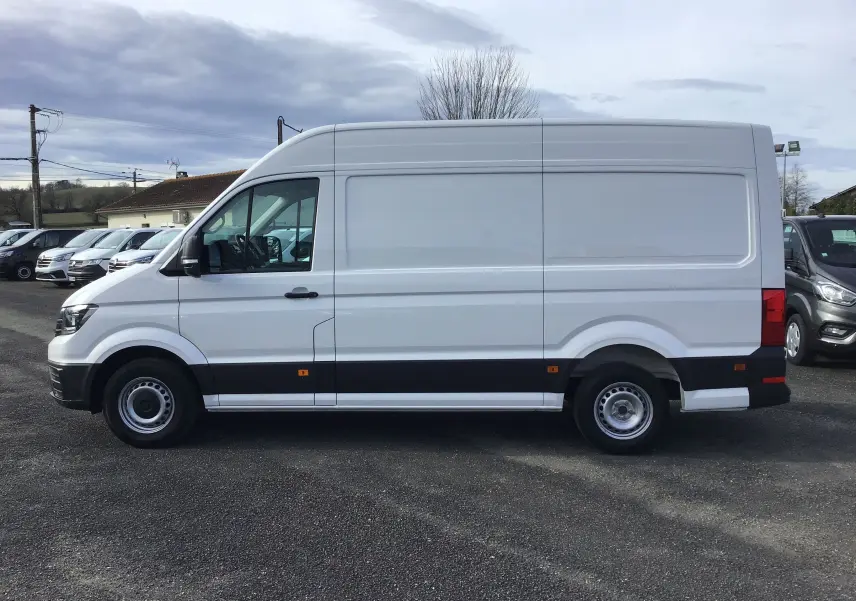Vue de profil côté gauche d’un utilitaire Volkswagen Crafter blanc L3H3 2021 avec bande noire basse et jantes acier.