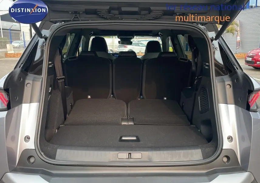 Coffre ouvert d'un Peugeot 5008 Hybrid gris Artense métal avec toit noir, vue arrière montrant les sièges rabattus.