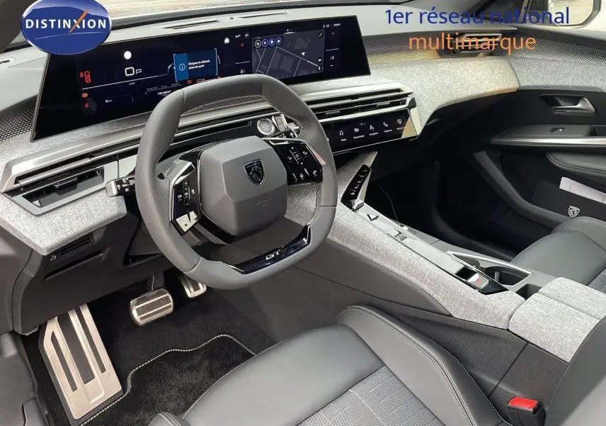 Intérieur du Peugeot 5008 Hybrid 2025 vu côté conducteur, volant compact et tableau de bord numérique moderne.