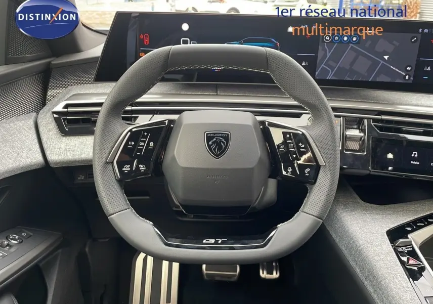 Volant GT en cuir perforé avec logo Peugeot, tableau de bord numérique et console moderne du Peugeot 5008 hybride 2025