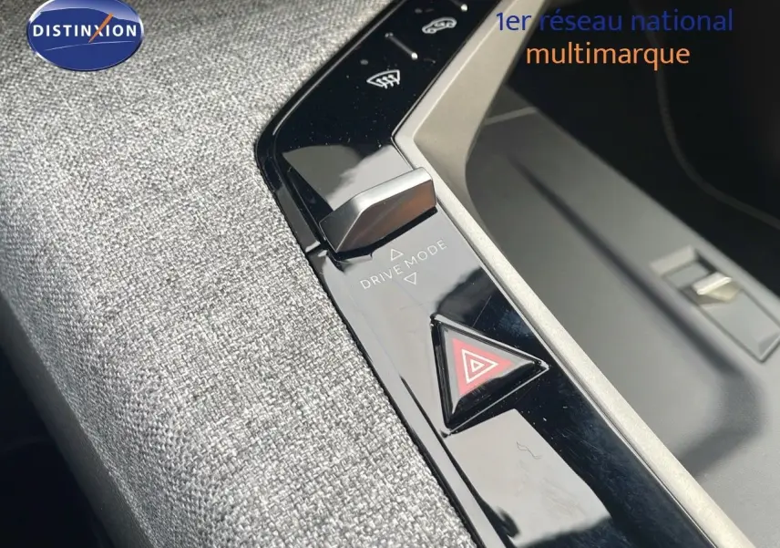 Gros plan sur la console centrale du Peugeot 5008 Hybrid 136ch GT 2025, mettant en valeur le bouton Drive Mode et le triangle de signalisation.
