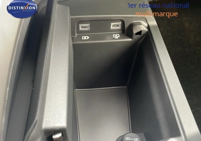 Vue rapprochée de la console centrale noire du Peugeot 5008 Hybrid 136ch GT 2025, montrant ports USB et prise 12V.