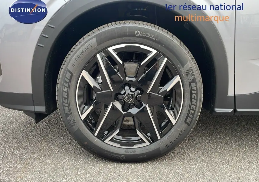 Gros plan sur la roue avant droite du Peugeot 5008 gris Artense métal avec jante noire et détails argentés.