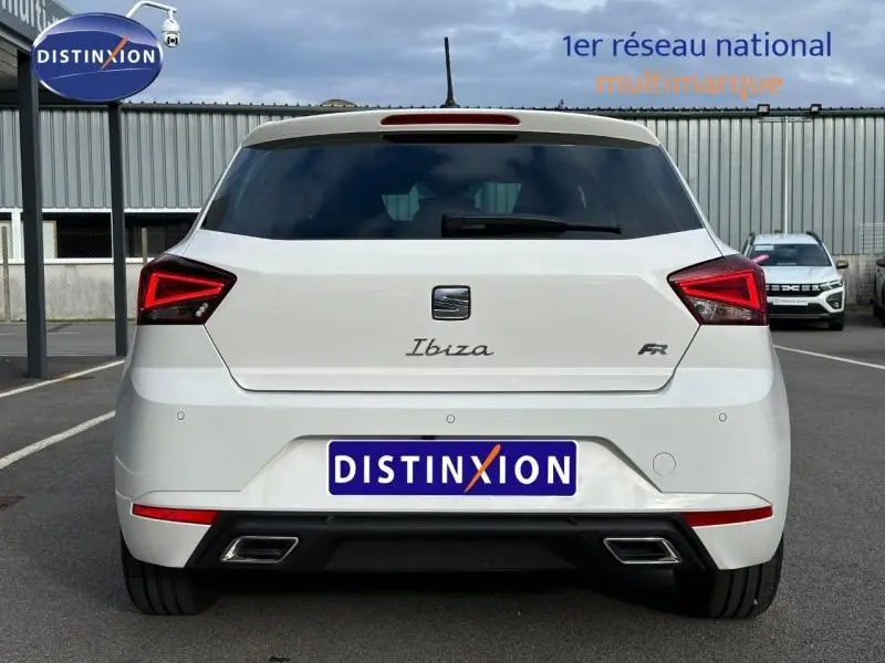 Vue arrière d'une SEAT Ibiza 1.0 TSI FR blanche Nevada métallisée avec feux LED et double sortie d'échappement rectangulaire.