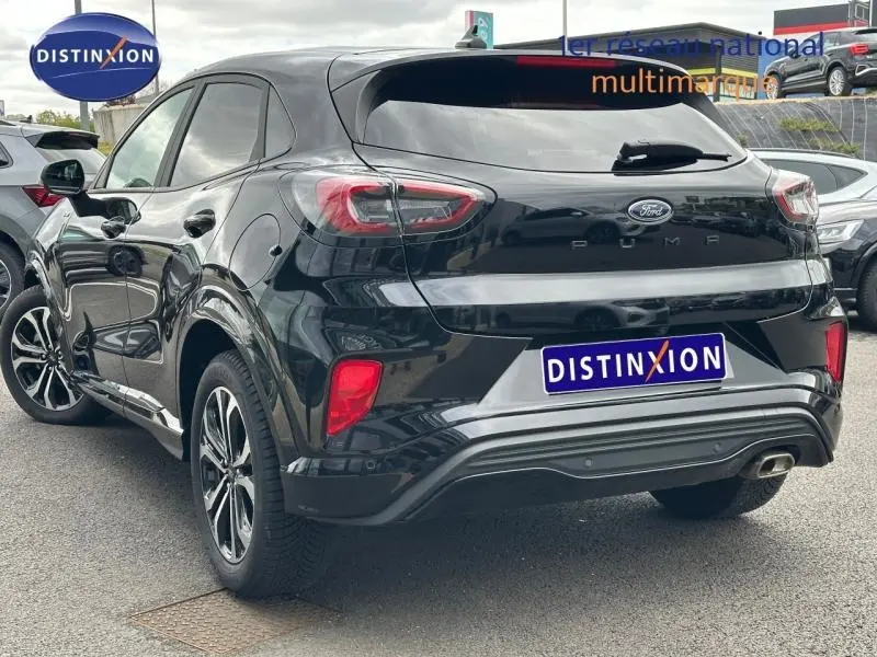 Vue 3/4 arrière droite du Ford Puma 2024 noir Agate métallisé avec feux arrière LED et sortie d'échappement chromée.