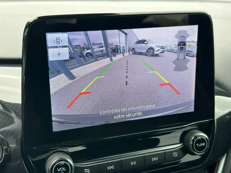 Écran de caméra de recul du Ford Puma 2024 noir Agate, vue arrière avec lignes de guidage colorées et véhicule à droite.