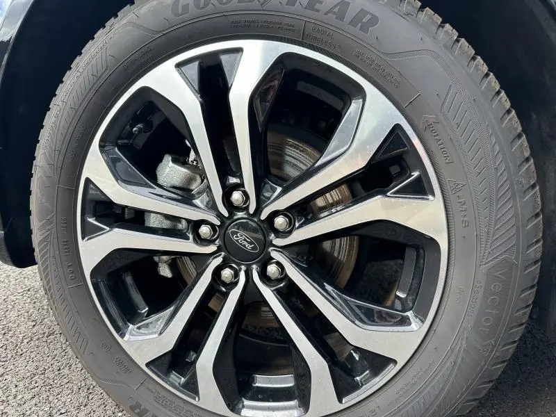 Gros plan sur la jante alliage noire et argentée du Ford Puma 2024, soulignant le logo Ford au centre du pneu Goodyear.