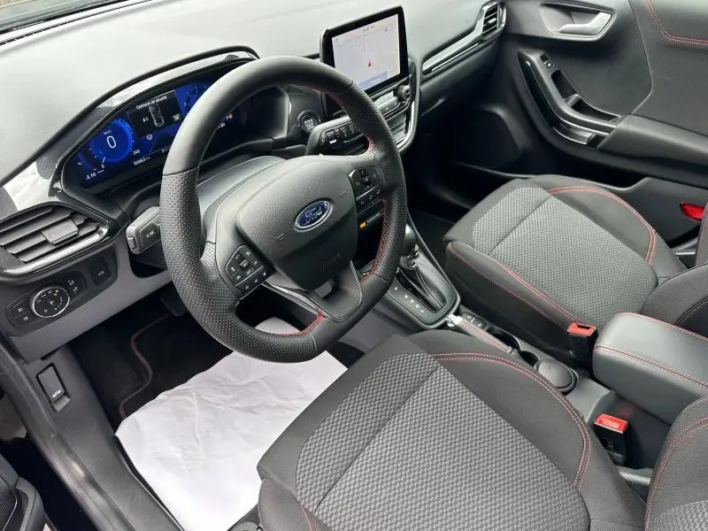Vue intérieure côté conducteur du Ford Puma 2024 noir avec volant multifonction et écran tactile central.