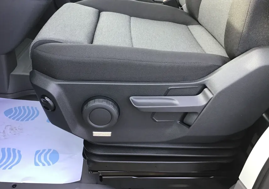 Gros plan côté gauche du siège conducteur gris à réglage manuel du Volkswagen Crafter blanc 2024 avec suspension Ergo Confort.