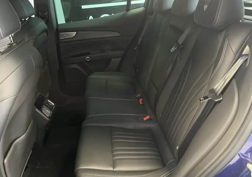 Vue intérieure côté droit des sièges arrière en cuir noir avec logo Trident brodé sur appuie-tête d'un Maserati Grecale bleu 2022.