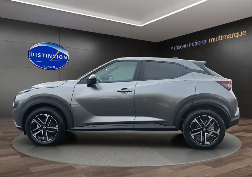 Profil côté gauche du Nissan Juke Full Hybrid 143 N-Connecta gris squale avec jantes alliage 17 pouces en showroom.