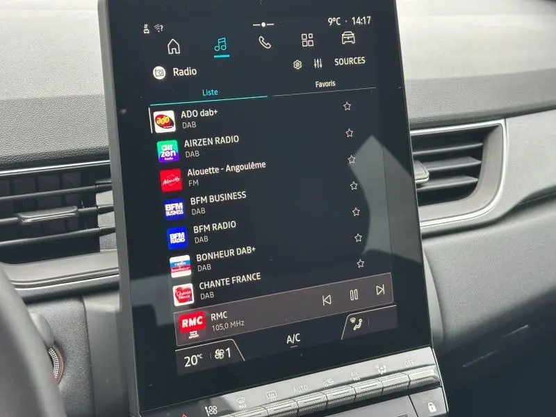 Écran tactile central de la Renault Captur 2025 affichant la liste des radios DAB, intérieur gris visible en arrière-plan.