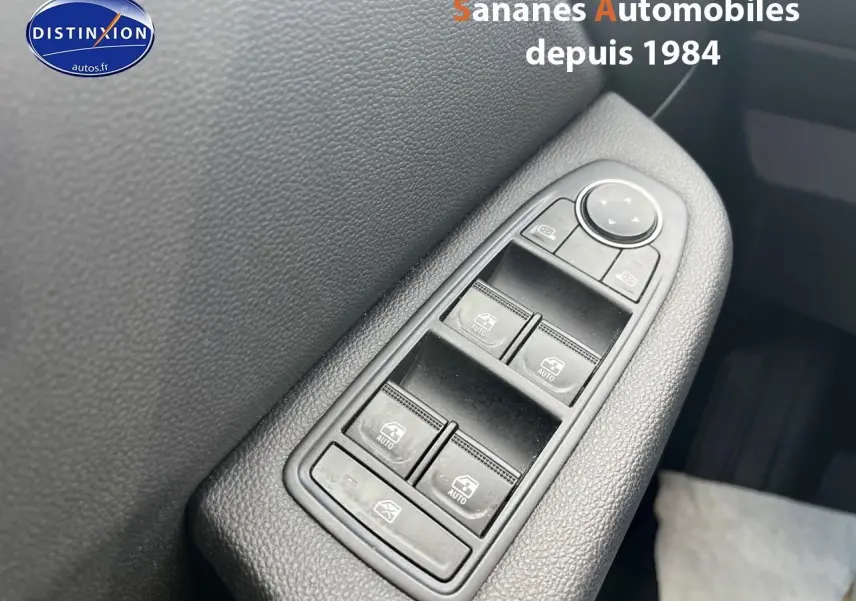 Gros plan sur les commandes des vitres électriques côté conducteur d'une Renault Clio Bleu Iron, finition Intens 2021.