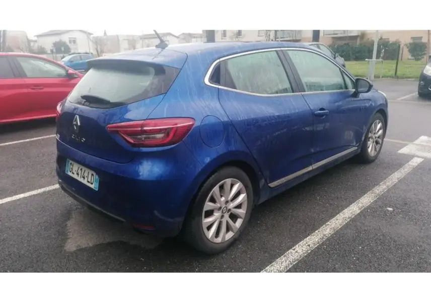 Renault Clio bleu Iron vue 3/4 arrière droit, garée sur parking avec jantes alliage et feux arrière LED.