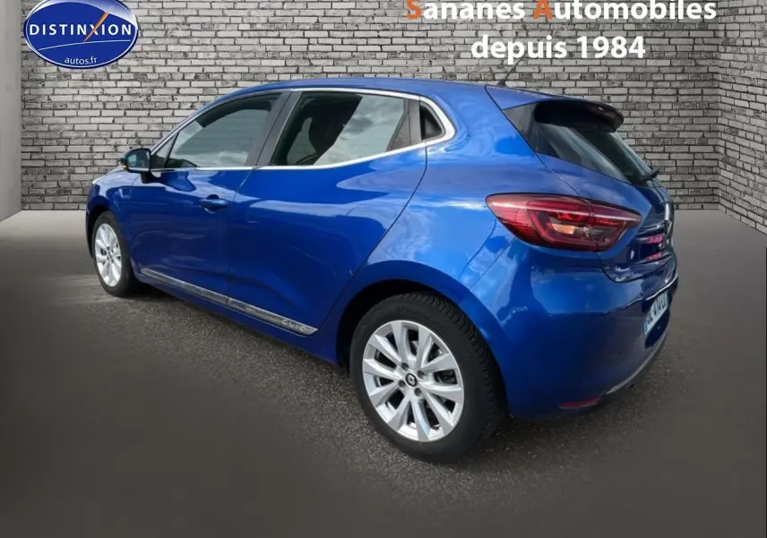 Renault Clio Bleu Iron vue 3/4 arrière droit, jantes alliage 16 pouces et feux arrière LED visibles.