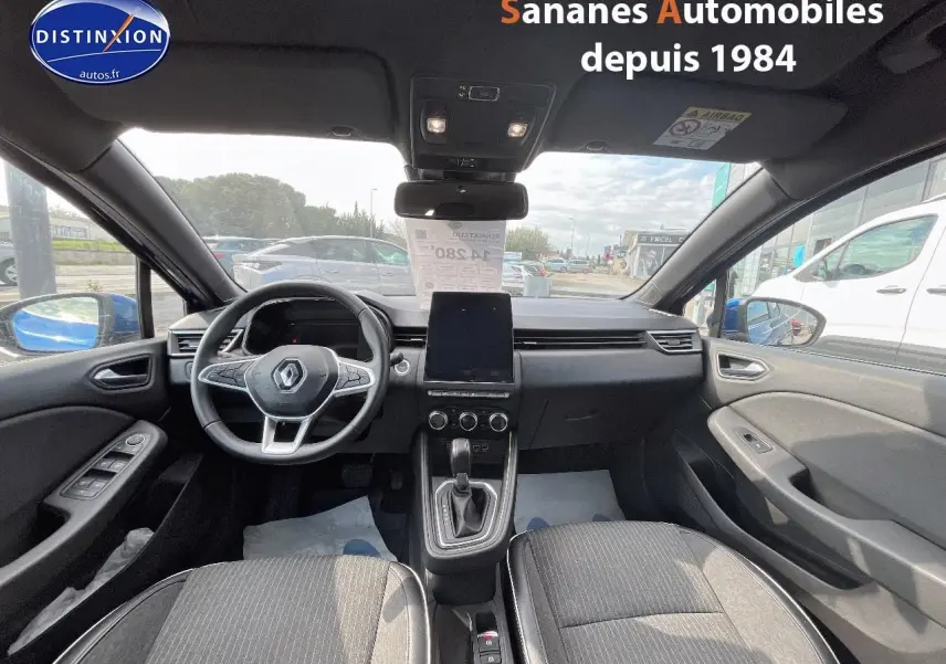 Vue intérieure avant de la Renault Clio 1.0 Tce 90 Intens 2021, montrant le tableau de bord noir et la console centrale avec écran tactile.