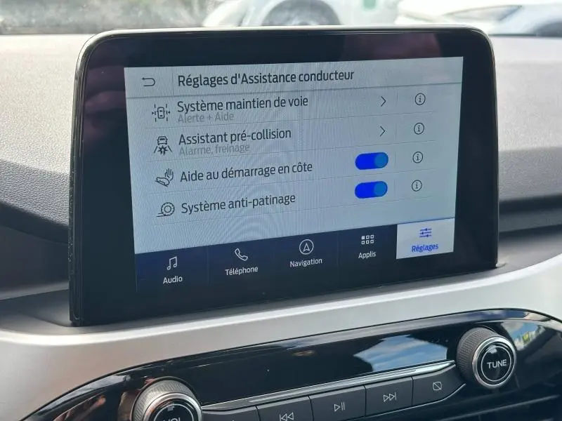 Écran tactile central du Ford Kuga 2024 affichant les réglages d'assistance conducteur, intérieur noir et gris.