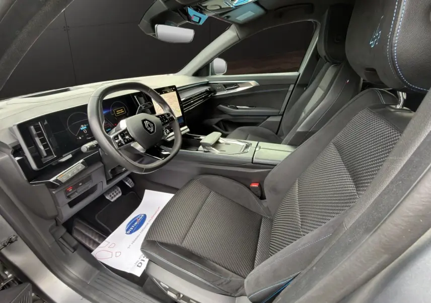 Intérieur avant droit du Renault Austral Iconic Esprit Alpine 2023, sièges noirs avec surpiqûres bleues et volant multifonctions.