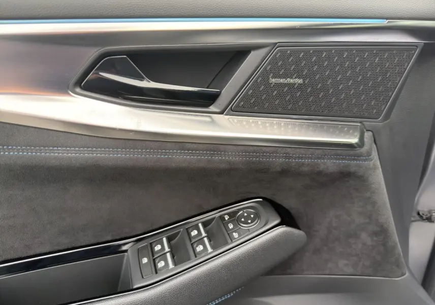 Détail de la porte côté conducteur du Renault Austral gris foncé, avec haut-parleur Harman Kardon et commandes électriques.