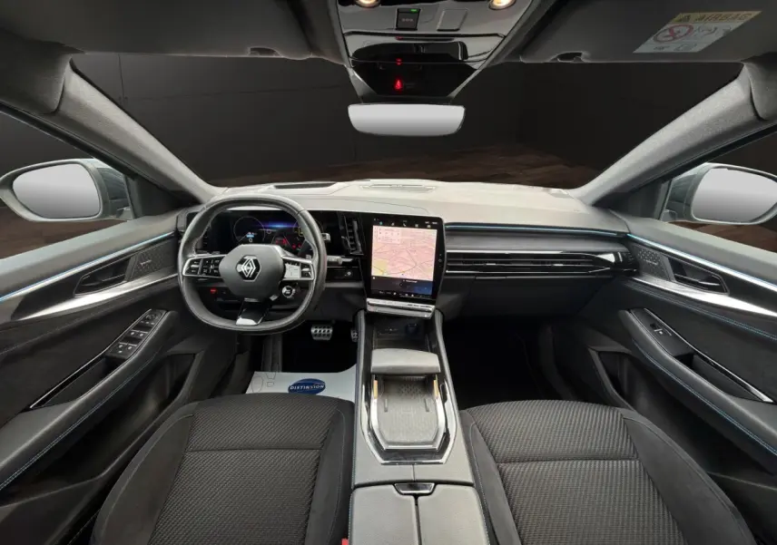 Vue intérieure avant du Renault Austral Iconic Esprit Alpine 2023, tableau de bord noir avec écran tactile central vertical.