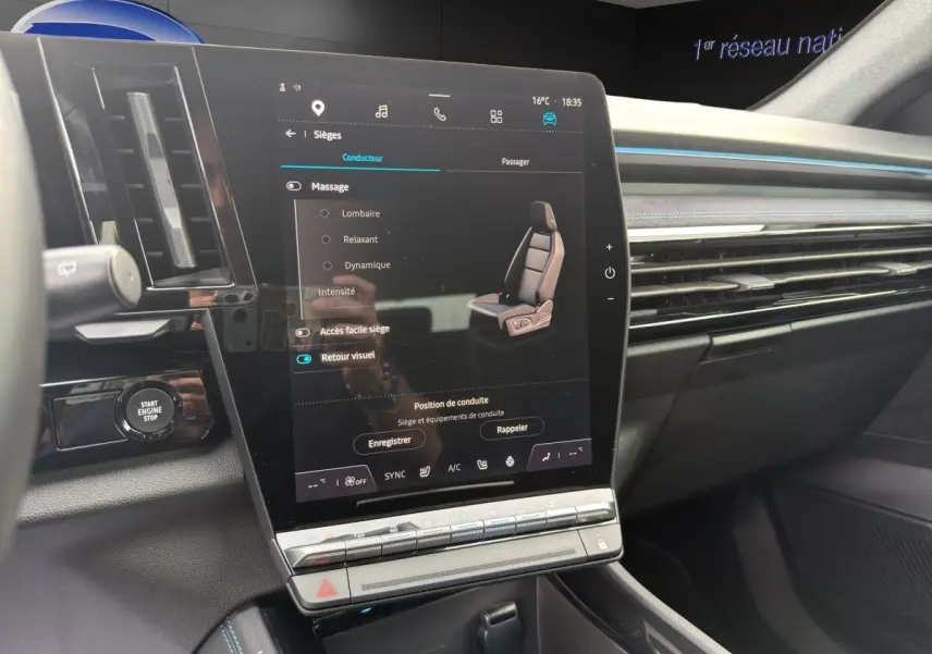 Vue intérieure du tableau de bord du Renault Austral gris foncé, avec grand écran tactile vertical et détails lumineux bleus.