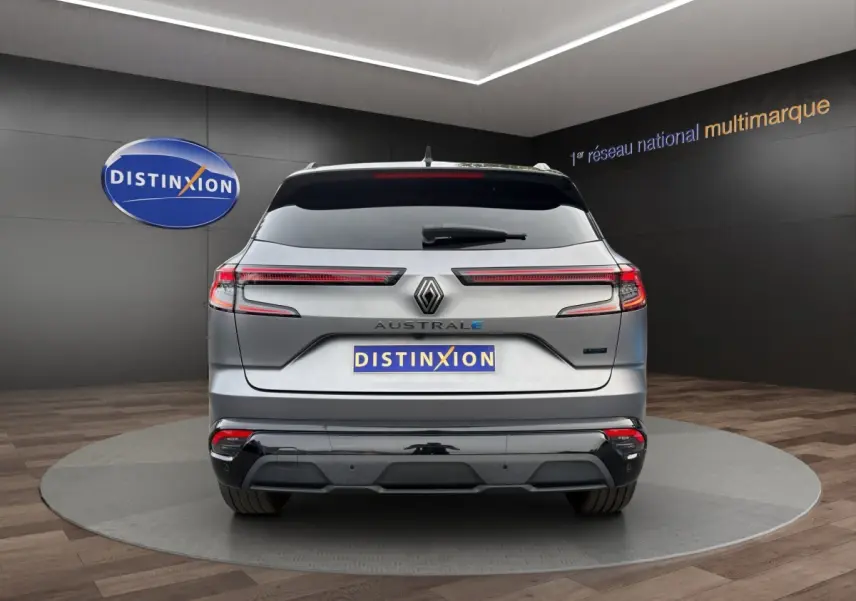 Vue arrière d'une Renault Austral gris foncé avec feux LED étirés et logo Distinxion en arrière-plan.