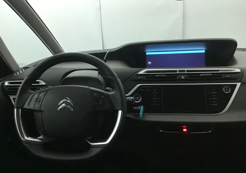 Vue intérieure du tableau de bord du Citroën Grand C4 Spacetourer gris, avec volant multifonction et écran tactile allumé.