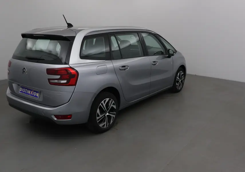 Vue 3/4 arrière droite d'un Citroën Grand C4 Spacetourer gris Artense avec feux arrière distinctifs et jantes alliage.