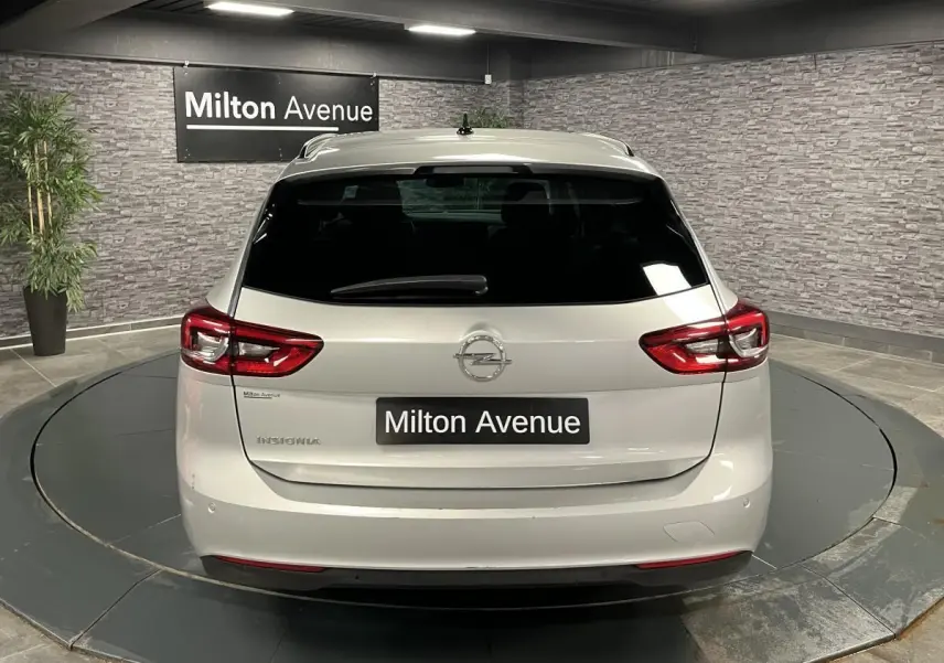 Vue arrière d'une Opel Insignia Sports Tourer gris métallisé avec feux arrière LED et lunette arrière surteintée.