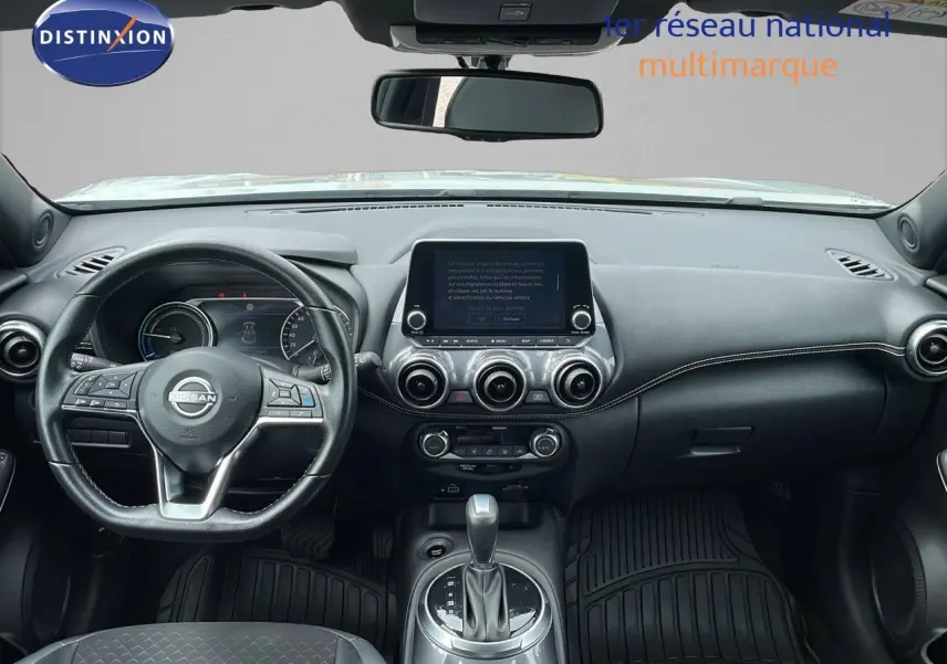 Intérieur du Nissan Juke Hybrid 2023 vu de face, tableau de bord noir avec écran tactile et volant multifonction.