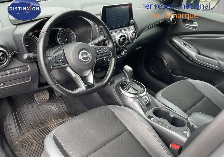 Intérieur avant droit du Nissan Juke Hybrid 143ch Business 2023 avec sellerie gris perle et console centrale brillante.