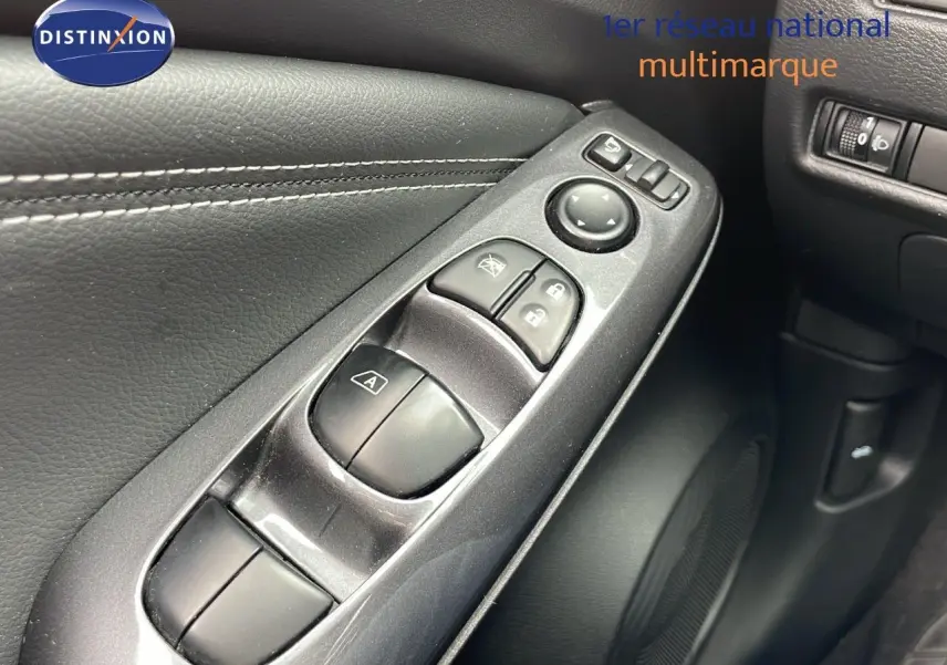 Gros plan sur les commandes de fenêtre et rétroviseurs côté conducteur d'un Nissan Juke gris perle 2023.