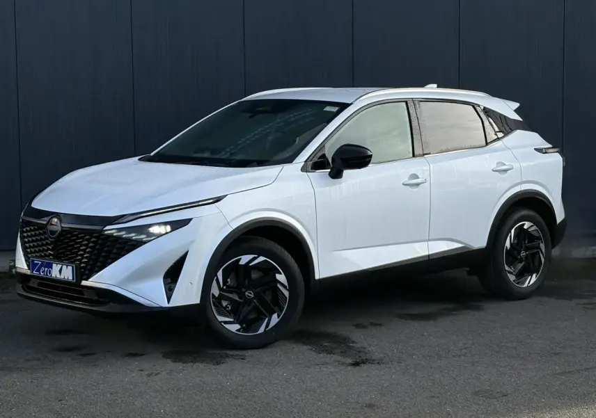Nissan Qashqai blanc nacré en 3/4 avant droit, avec jantes alliage noires et toit contrasté noir.