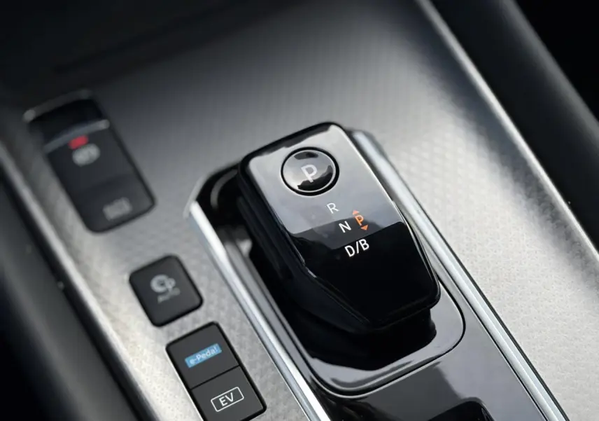 Gros plan sur la commande de boîte automatique noire du Nissan Qashqai blanc nacré, avec boutons e-Pedal et mode EV visibles.