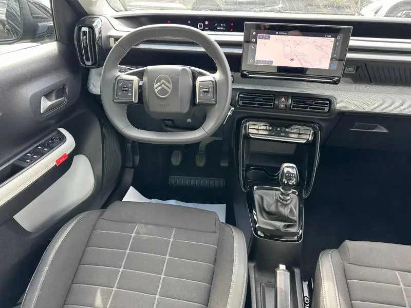 Vue intérieure avant de la Citroën C3 1.2 Turbo noire, volant multifonction, écran tactile GPS et boîte manuelle.