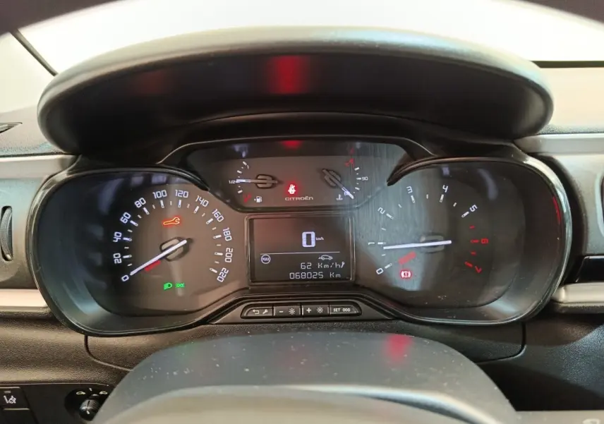 Vue rapprochée du tableau de bord noir de la Citroën C3 2021, affichant compteur digital et voyants allumés.