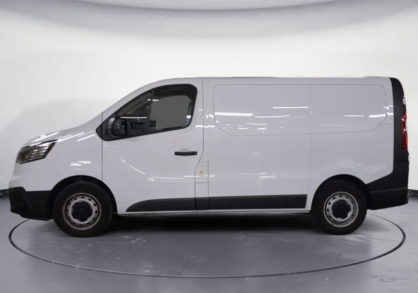 Vue de profil côté gauche du Renault Trafic Fourgon blanc minéral 2024 avec détails noirs sur les bas de caisse et jantes acier.