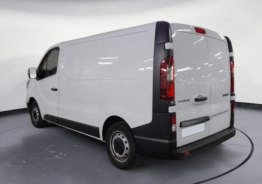 Vue 3/4 arrière droite du Renault Trafic Fourgon blanc minéral 2024 avec portes arrière fermées et éléments noirs contrastants.