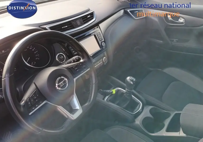 Intérieur noir du Nissan Qashqai 2018, vue sur le volant, tableau de bord et levier de vitesse manuel.