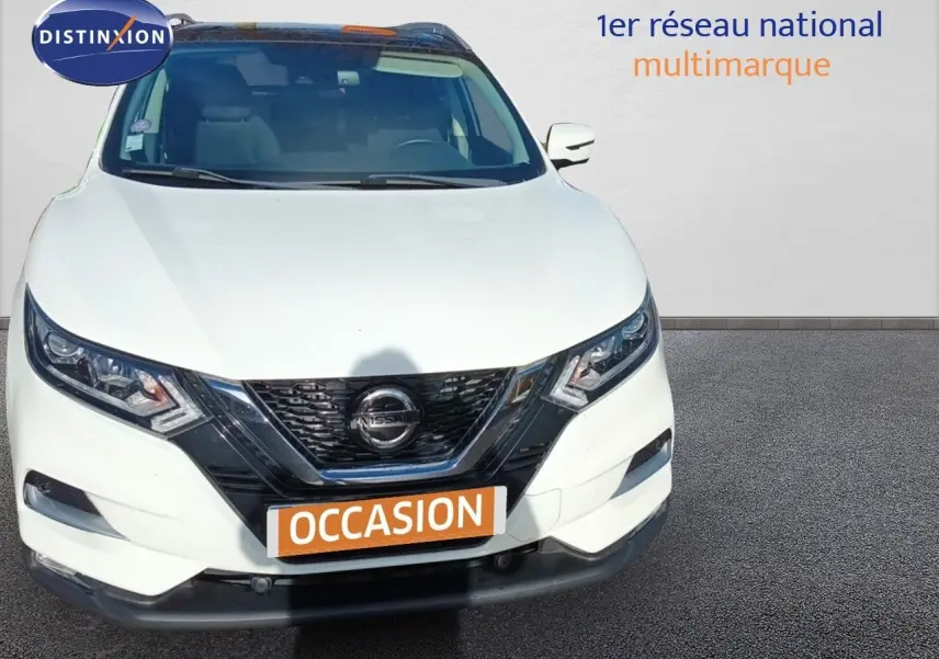 Vue avant d'un Nissan Qashqai blanc de 2018 avec calandre noire et plaques "OCCASION" en orange.