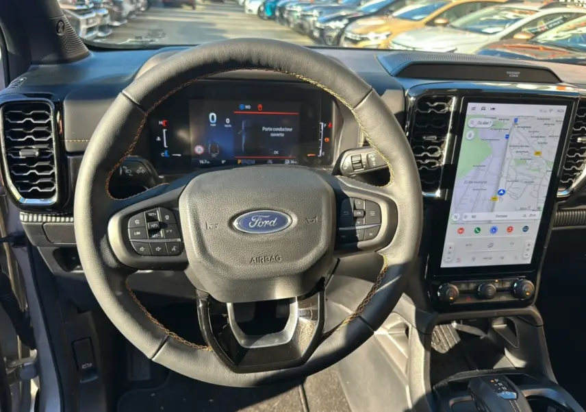Vue intérieure centrée sur le volant cuir multifonctions Ford Ranger 2025 avec écran tactile GPS vertical.