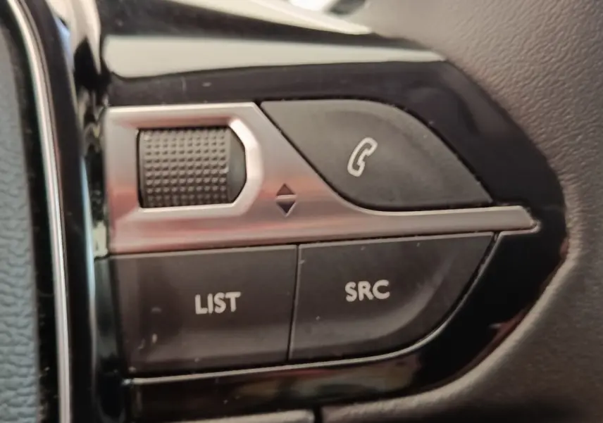 Gros plan sur les commandes multifonctions noires et argentées du volant du Peugeot 5008 gris foncé, version 2020.