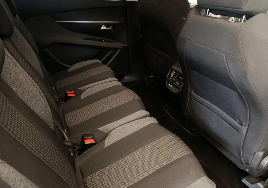 Vue intérieure côté droit des sièges arrière gris foncé à motifs du Peugeot 5008 avec commandes de climatisation au centre.
