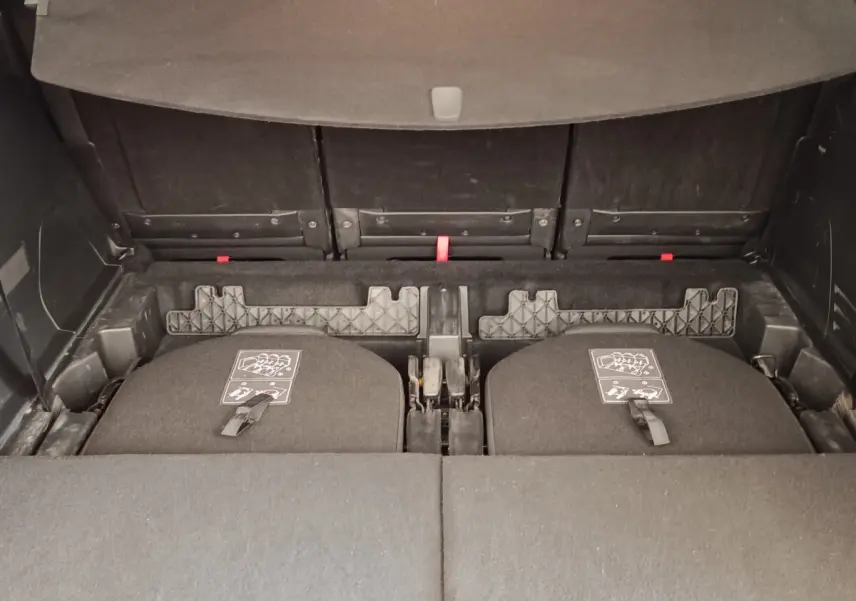 Vue intérieure du coffre du Peugeot 5008 gris foncé, montrant la 3ème rangée de sièges rabattus et le plancher plat.