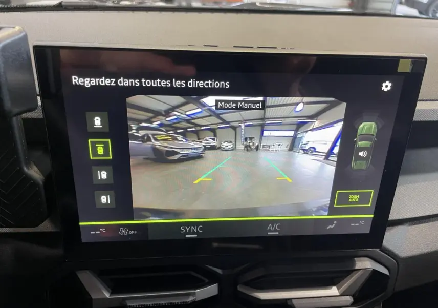Écran tactile intérieur montrant la caméra de recul d'un Dacia Bigster gris schiste dans un garage.